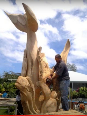 Master-Carver-and-new-Mission-President-Sitiveni-Fehoko-carves-a-dolphin,-whale-and-mahimahi-out-of-a-tree-trunk.--