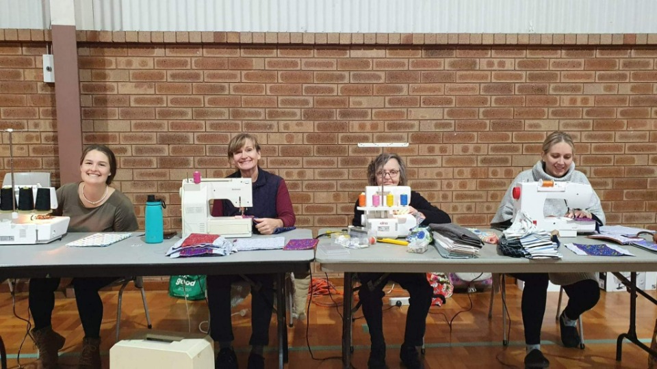 Volunteers sew bags for 