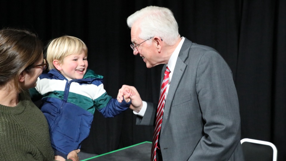 Elder D. Todd Christofferson greets a young boy and his mother in Hobart, Australia. 21 May 2023.