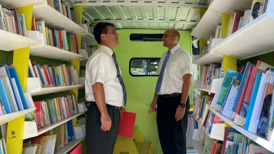 Church leaders, Elder Frédéric Riemer, Area Seventy, and Manea Tuahu, welfare and self-reliance services look inside the library mobile unit on the island of Moorea, French Polynesia.