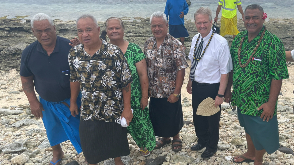 A-group-of-members-from-the-Aunu'u-Ward-show-Elder-Nattress-the-site-of-the-'miracle-of-the-sand.-American-Samoa,-November-2021.