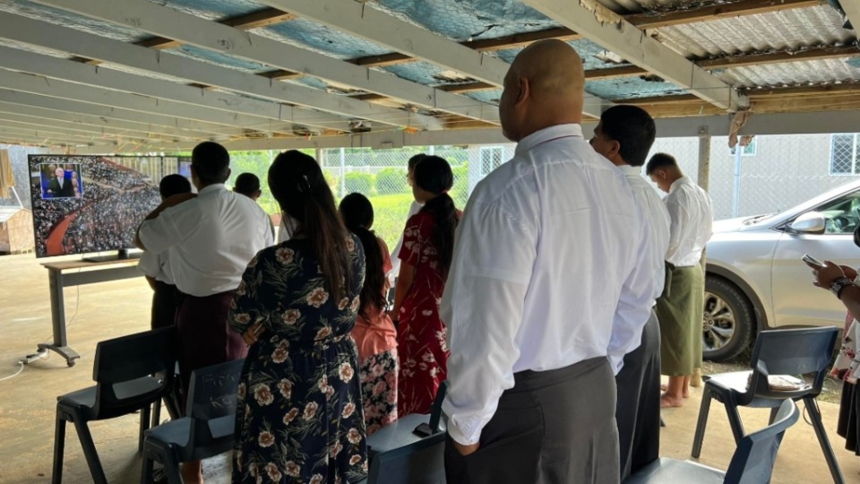 Tongan-neighbours-gathered-at-a-family's-home-to-watch-General-Conference-sessions-on-16-April-2023.-Those-pictured-were-standing-to-sing-a-hymn-as-part-of-the-conference-session.