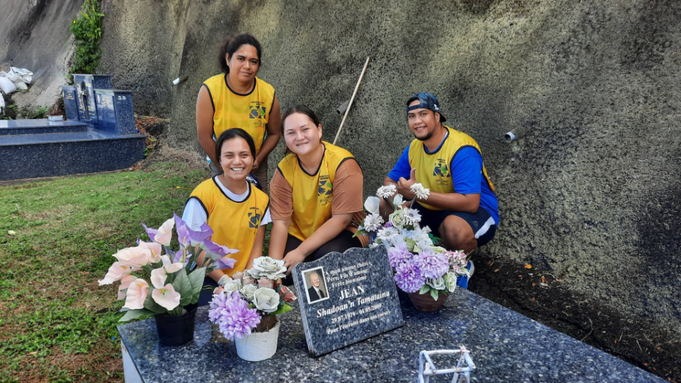 Mihiau-Jean-and-friends-clean-her-father's-tomb-and-other-graves-of-loved-ones-on-All-Saints-Day-in-French-Polynesia-on-Tuesday,-1-November-2022.