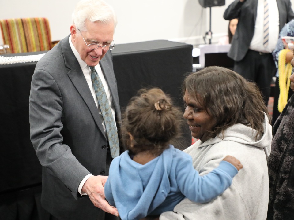 Elder Christofferson greets a mother and child in Alice Springs, Australia on 25 May 2023.